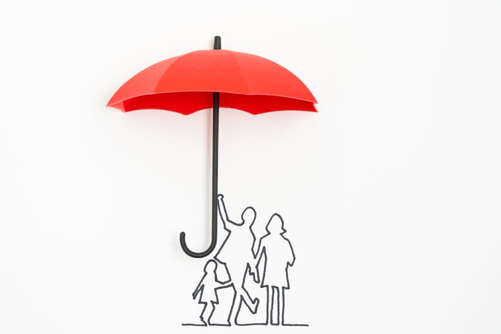 Family protection insurance concept using red umbrella