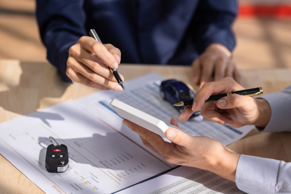 Car Insurance document or lease concept the car broker assisting his customer and explaining the